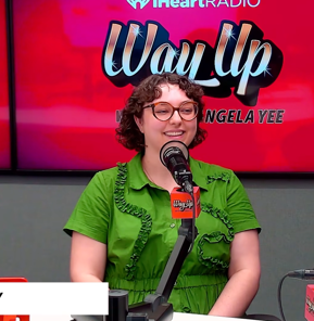 Olivia Brady sits behind a microphone in the podcast booth of Angela Yee's how, Way Up with Angela Yee