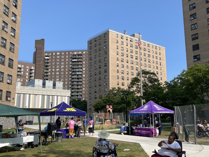 Pat Jewett volunteering outside under a purple NYC Votes tent.