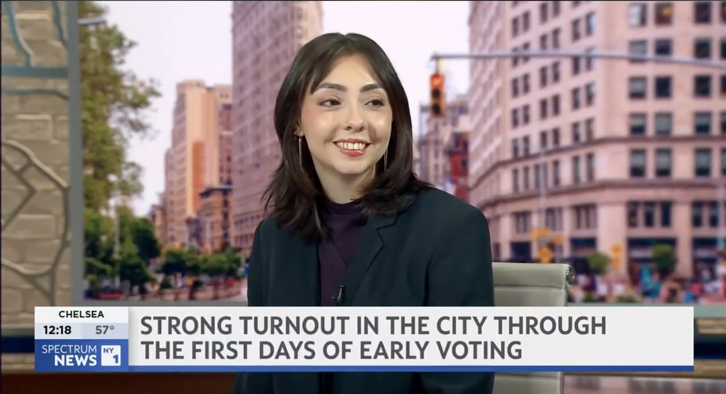Jadel Munguia smiles while seated on a Spectrum News NY1 news set. A lower-third banner reads, “Strong turnout in the city through the first days of early voting.”